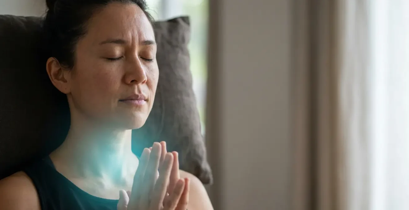 Persona in meditazione con focus sulla zona della gola illuminata da luce azzurra