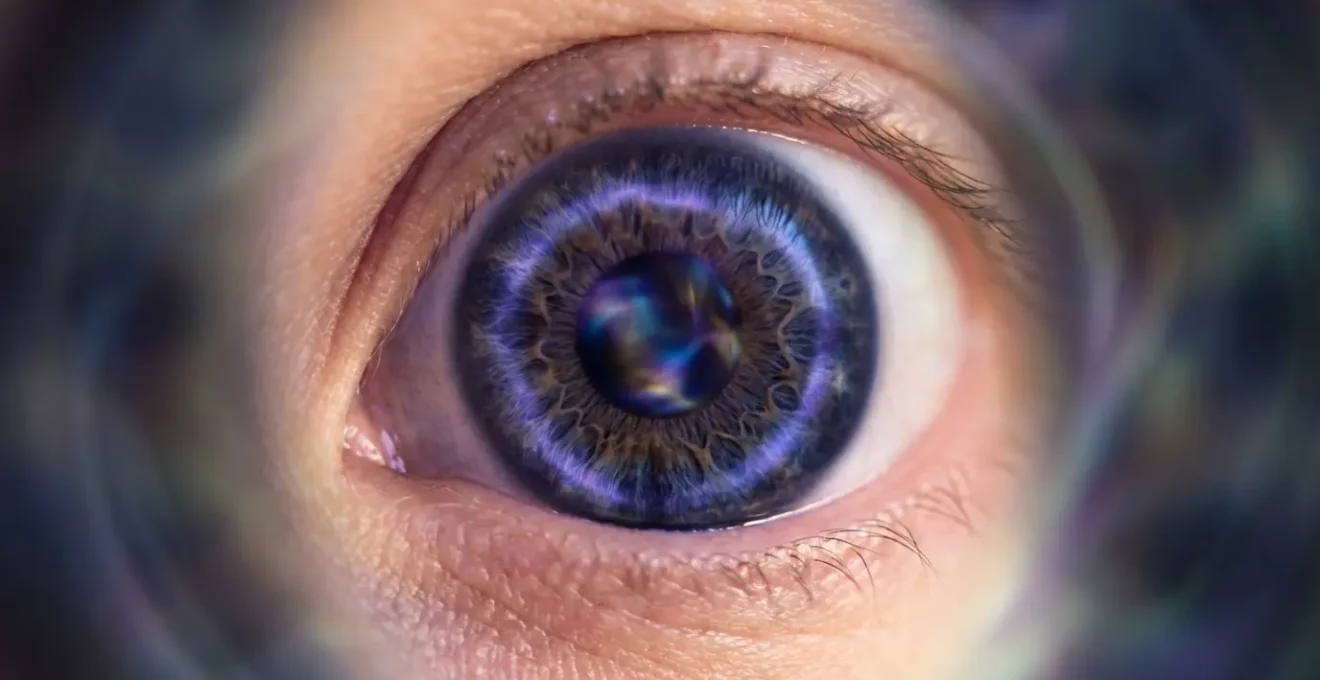 Primo piano meditativo di occhio con riflessi viola e indaco che suggeriscono percezione intuitiva